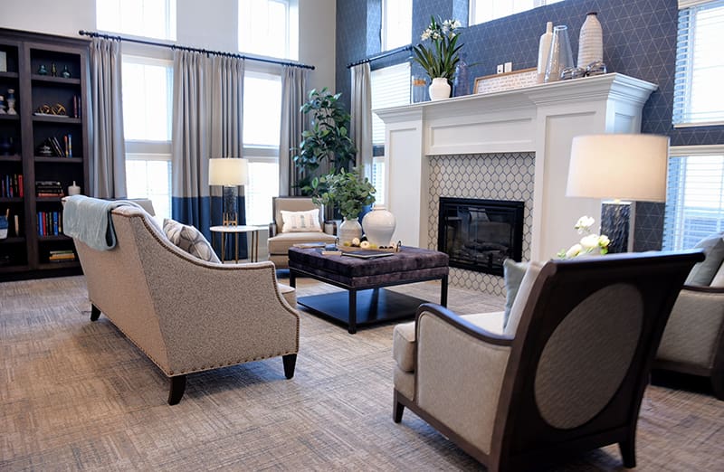 seating around fireplace with bookcases and art