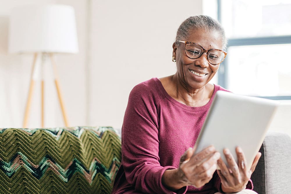 Senior woman using a tablet to stay connected at Charter Senior Living of Hopkinsville in KY